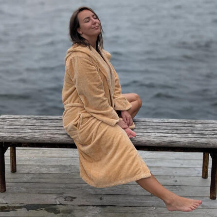 Andrea Endres Kawalec Wellness Travel Specialist at Inside Wellness Travel Woman in a robe at a lake relaxing